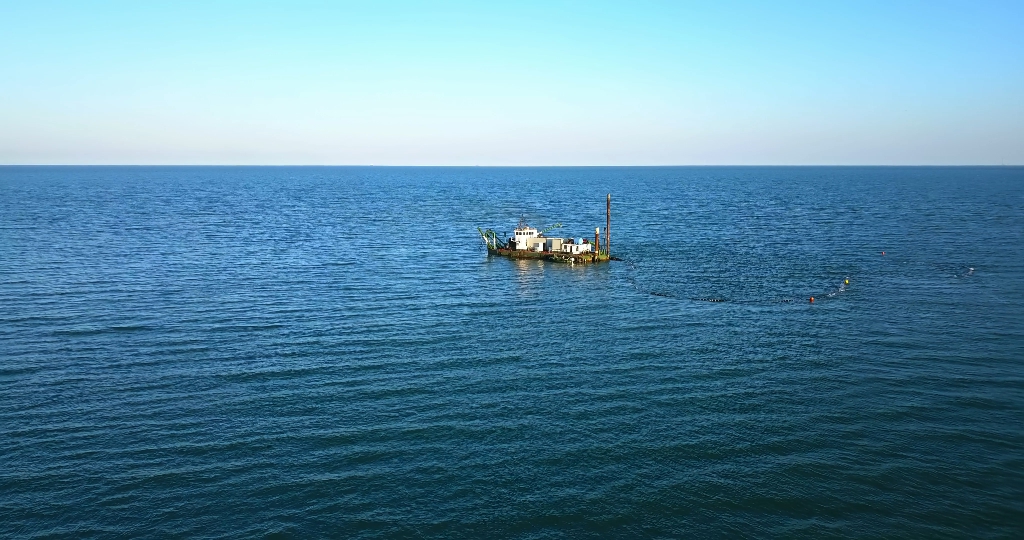 Ship to suck up the sand near a dike