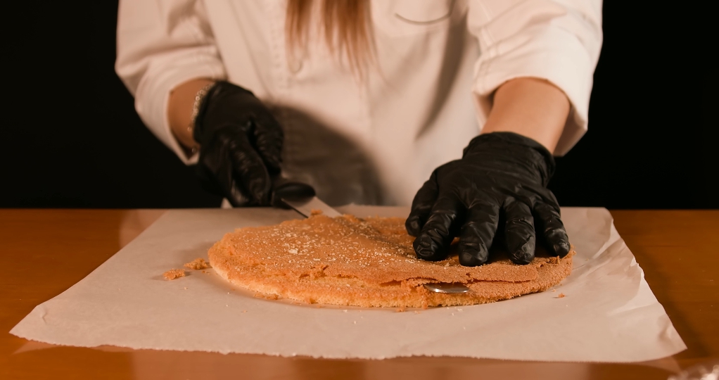 Una torta tonda rotonda viene tagliata con il coltello