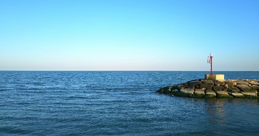Overflight above the sea and a stone dam