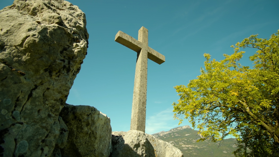 Cross monument stands on pile of big stones in Italy