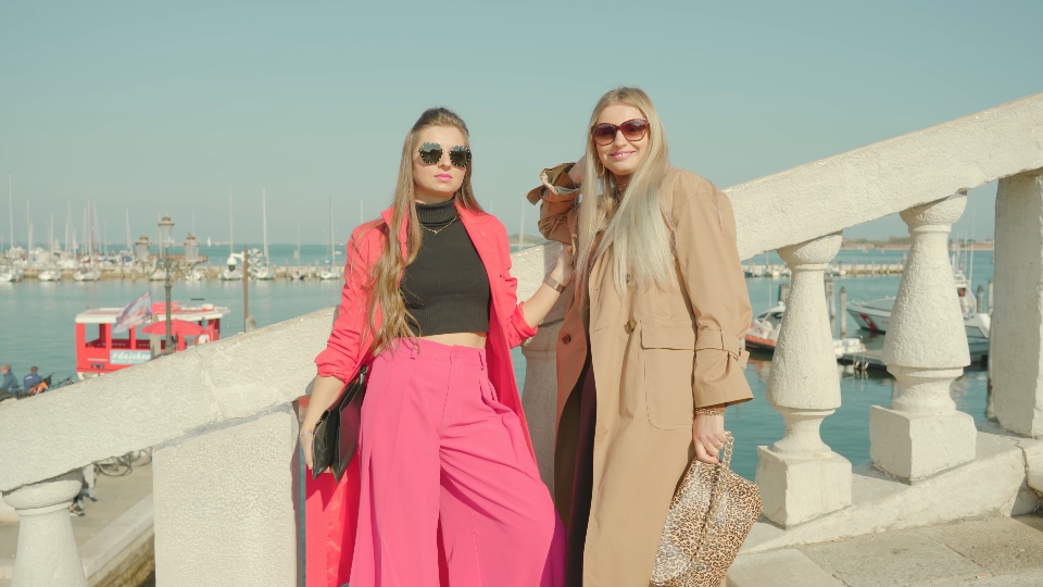 Young women enjoy weather on bridge over Venetian lagoon