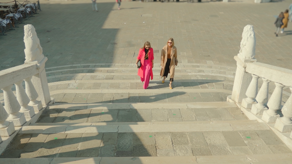 Women in fasionable clothes communicate going upstairs