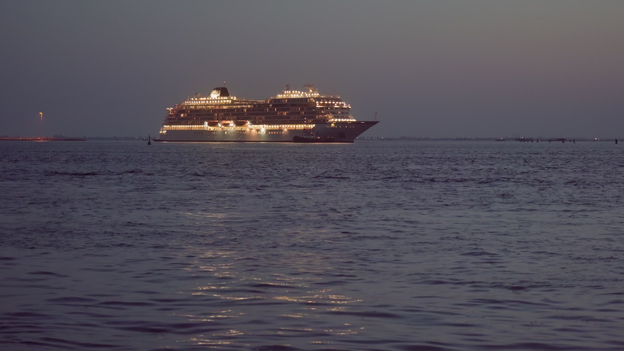 Nave da crociera illuminata di sera in laguna