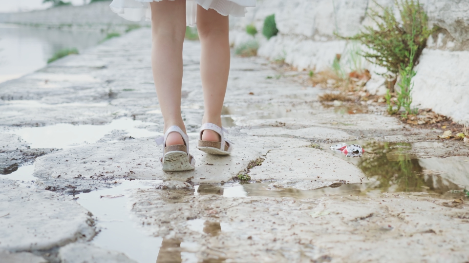 Legs of the little girl walking on the stones