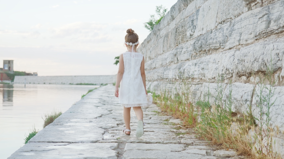La bambina cammina sui sassi della diga