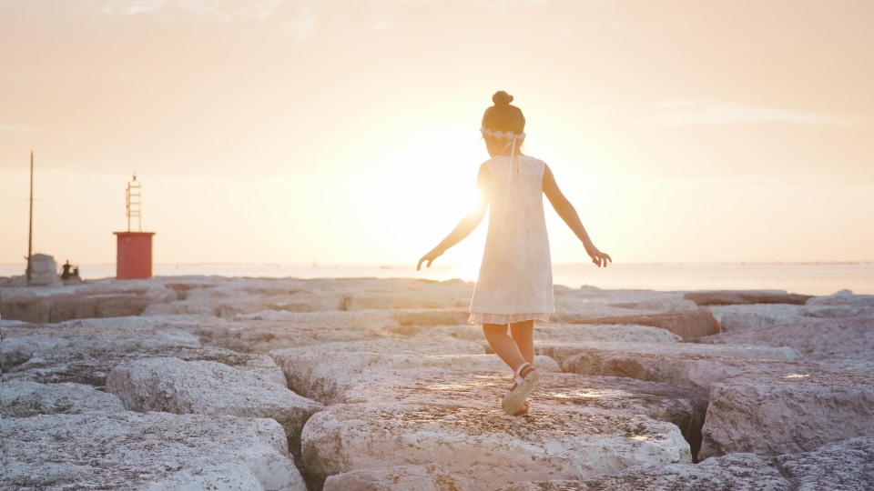 Little girl walks at sunset