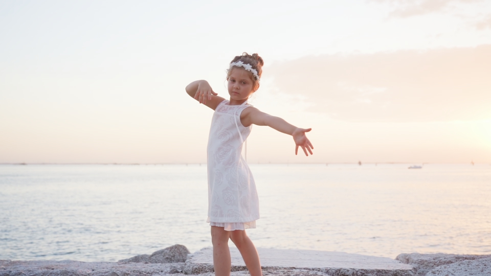 La bambina balla al tramonto sulla laguna