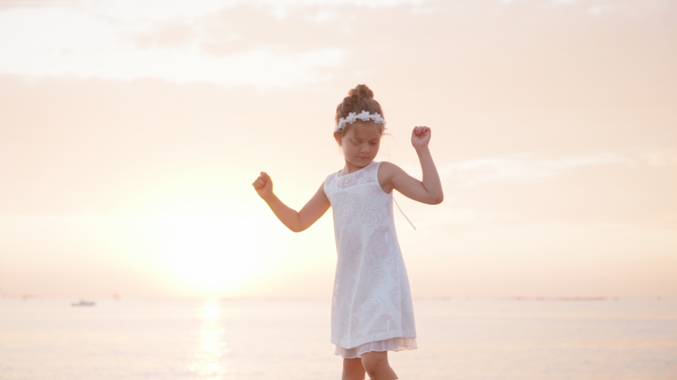 La bambina balla e si diverte al tramonto