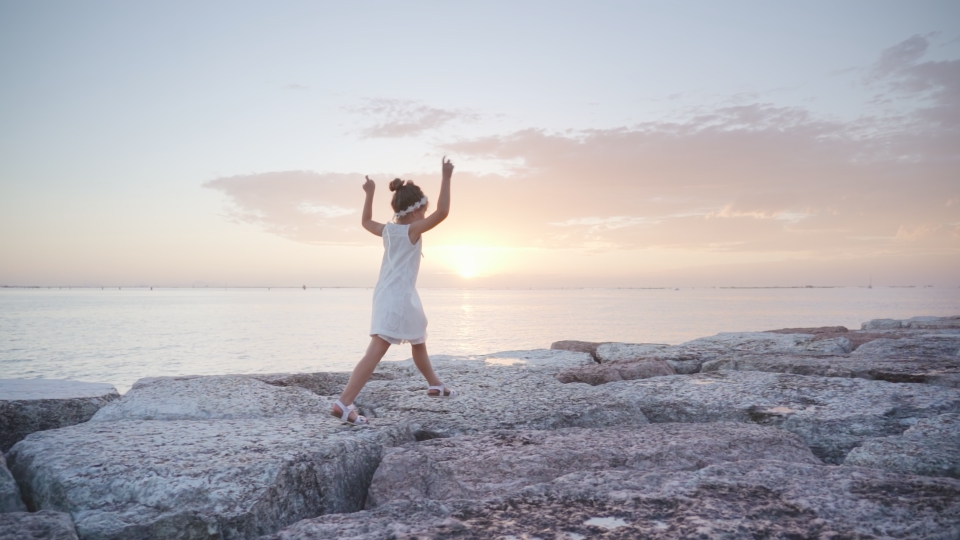 Little girl walks having fun at sunset on the lagoon