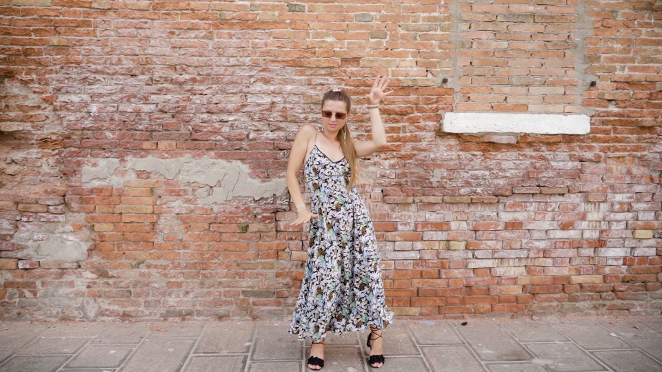 Divertimento in Movimento: Donna Balla Allegremente davanti a un Muro di Mattoni