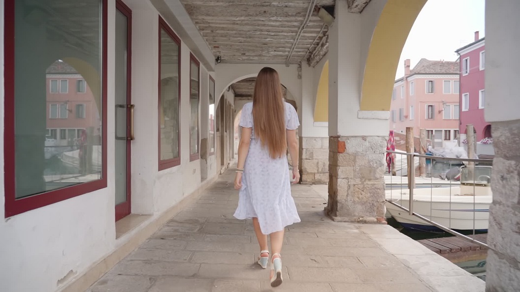 Venezia: Donna che Cammina sotto le Case Veneziane in Estate