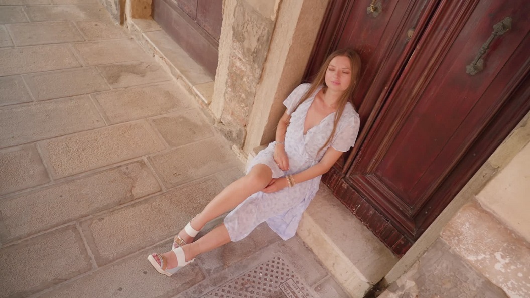 Giovane Donna Seduta in Strada Davanti alla Porta di una Casa Veneziana