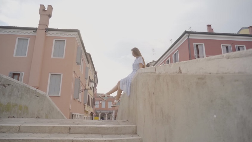 Elegance in Motion: A Woman Sitting on the Edge Moves Her Legs Gracefully