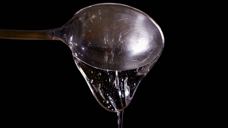 Gocce di crema trasparente dal cucchiaio