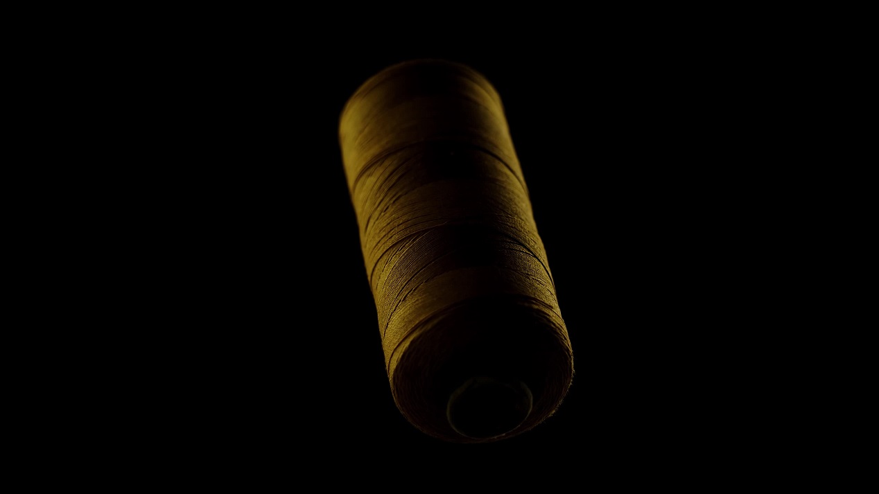 Filo per cucire color oro su sfondo nero