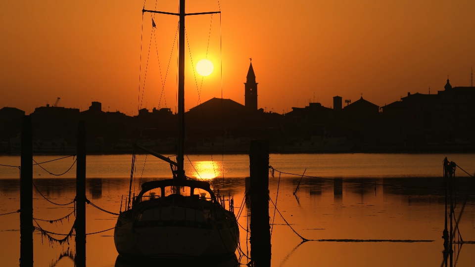 Una barca a vela al tramonto sulla laguna di Chioggia