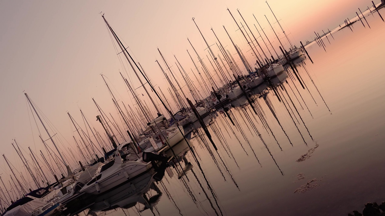 Barche a vela parcheggiate con riflessi nell’acqua