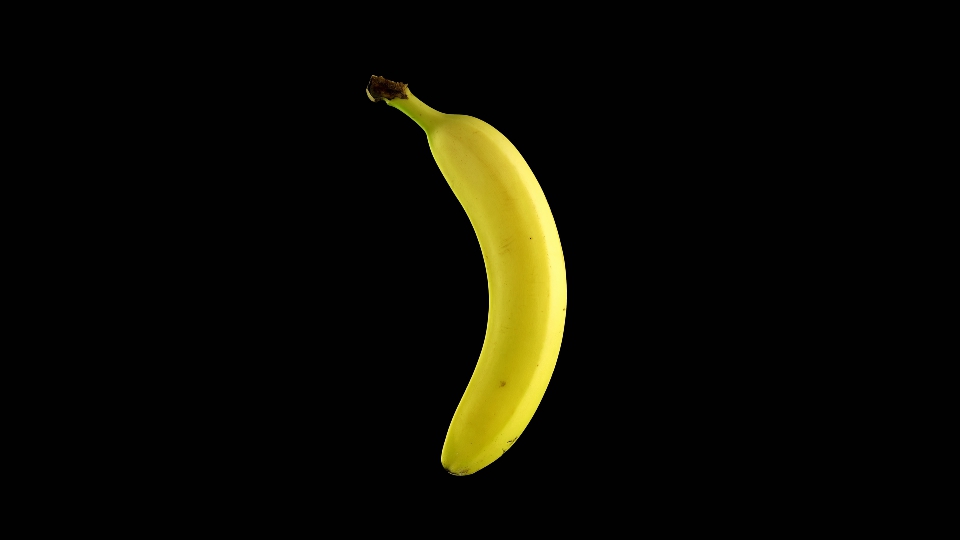 La banana gialla ruota su sfondo nero