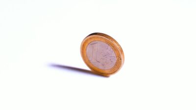 Moneta da 1 euro ruota su uno sfondo bianco