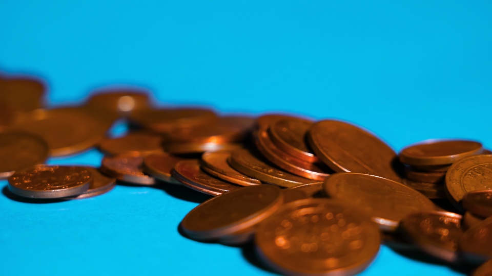 Monete di un centesimo euro su uno sfondo blu