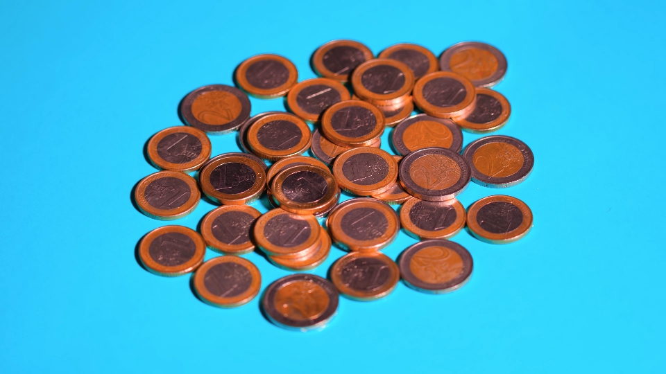 Euro Coins Rapidly Spinning on a Blue Background