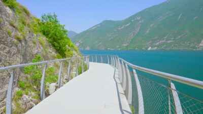 Strada sospesa sulle rocce di montagna al lago nelle Alpi