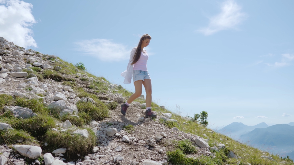 Donna scende dalla montagna con sassi caduti