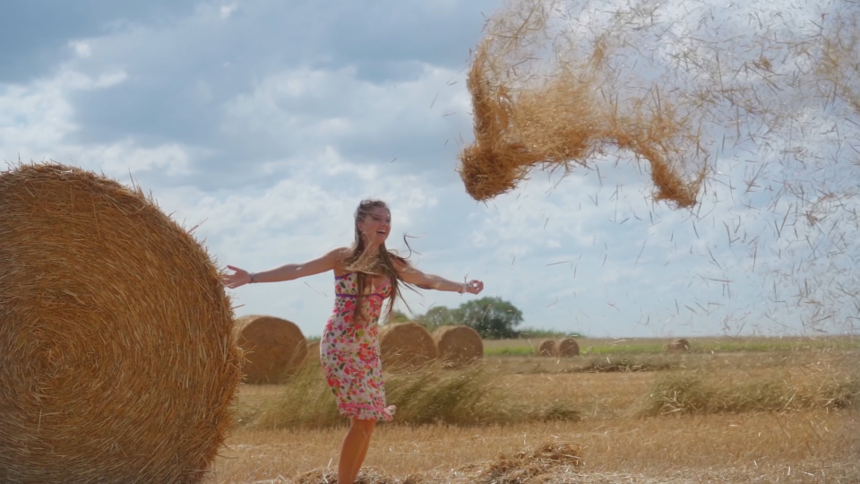 Donna gioca felice con il fieno d’estate
