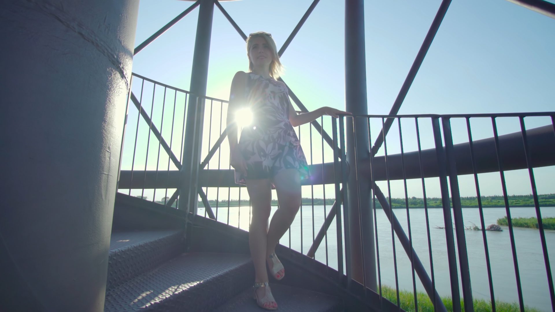 Smiling blonde woman descends the metal stairs