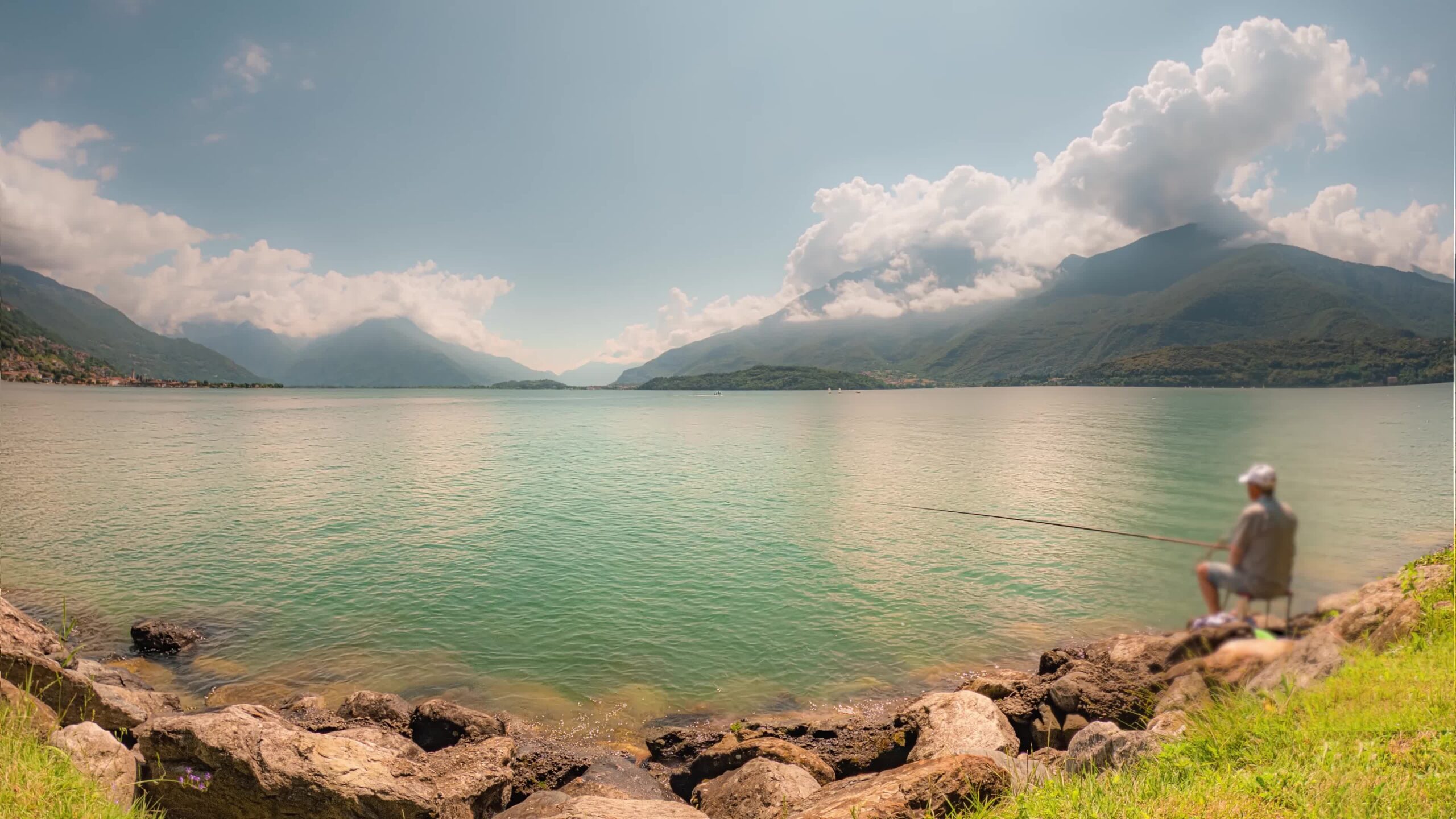 Timelapse of Lake Como with Fisherman and Clouds in Blue Sky Above Mountains