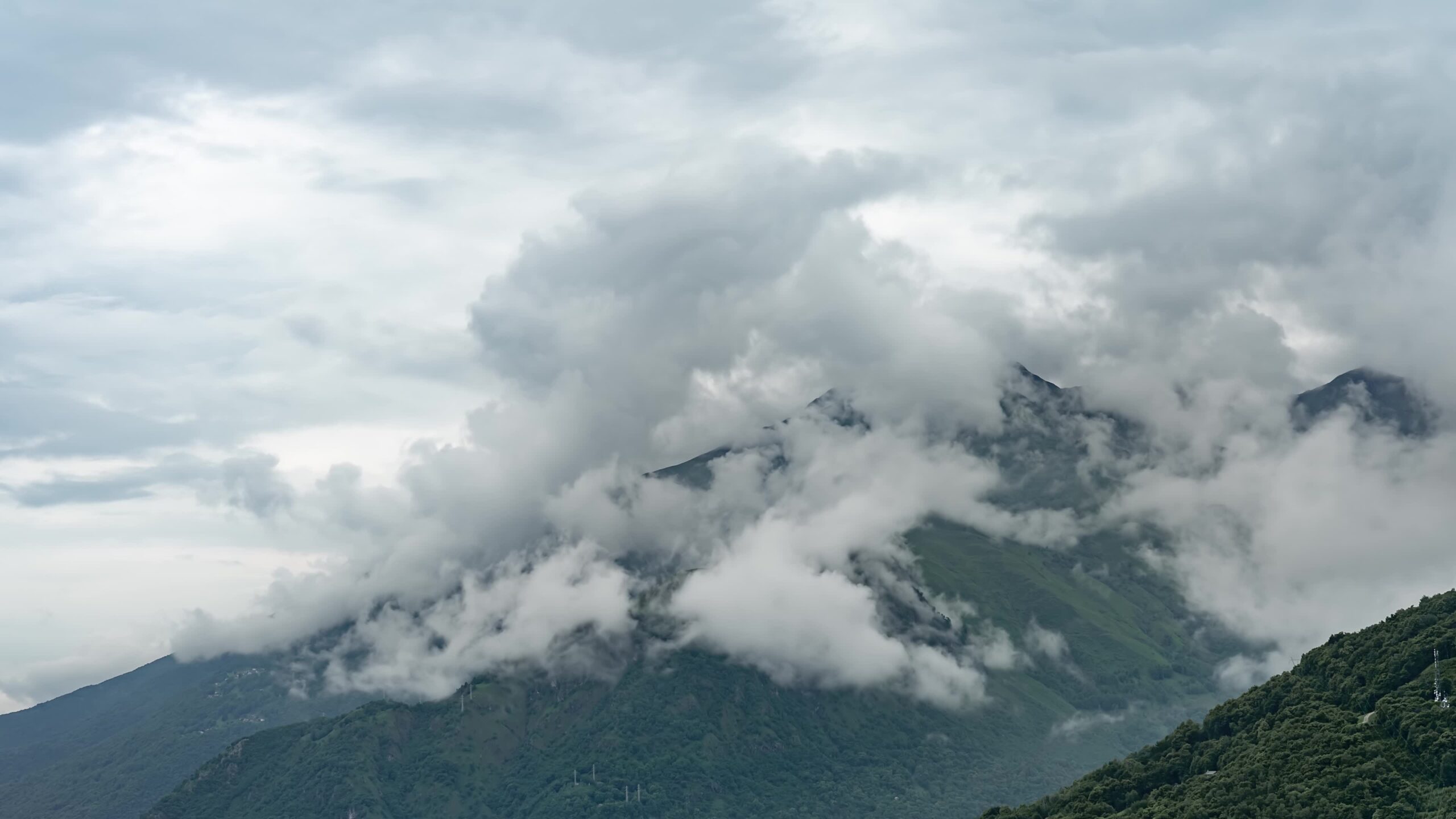 Nuvole dopo la pioggia tra montagne verdi