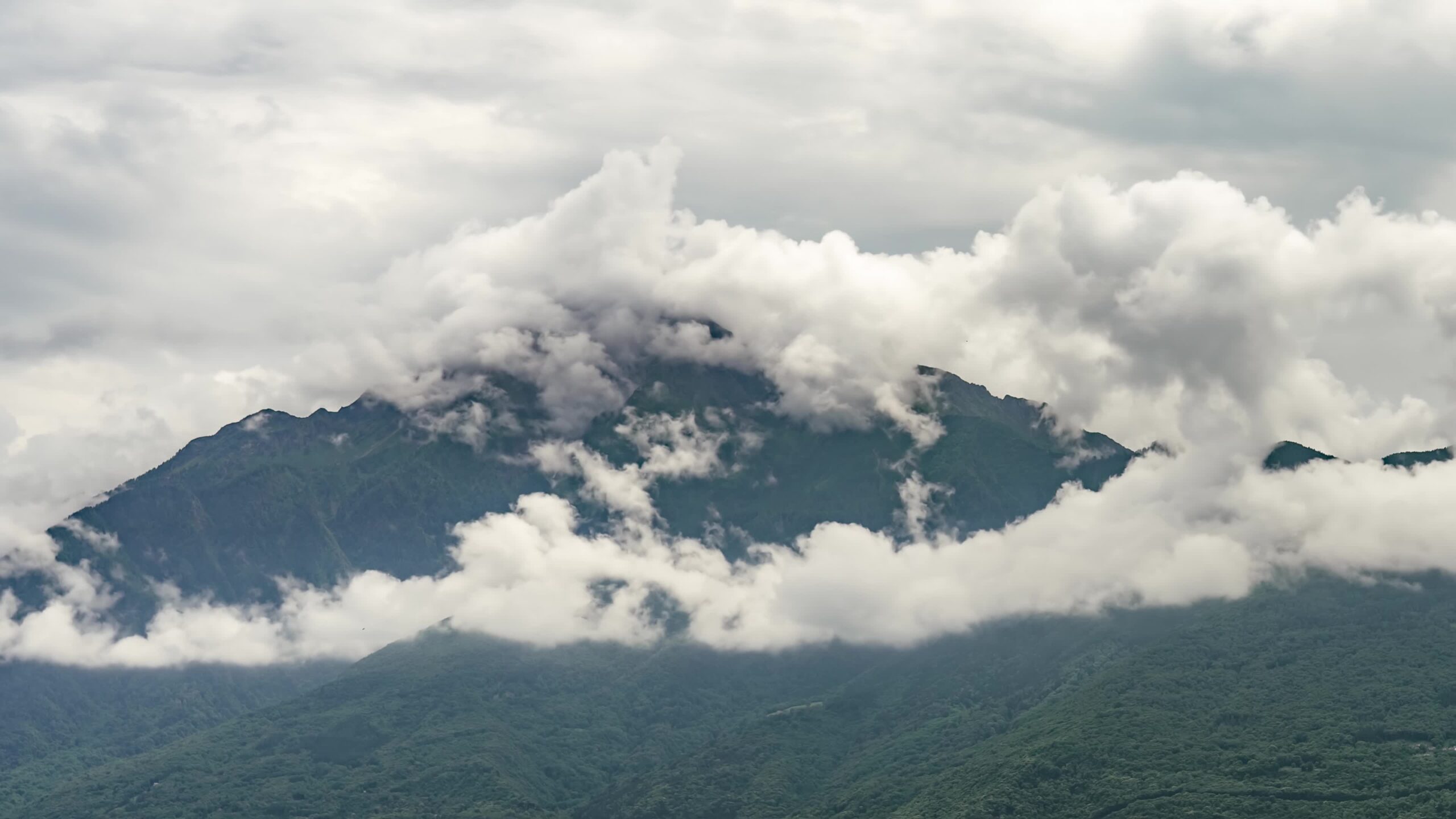 Nuvole si evaporano dalle montagne verdi