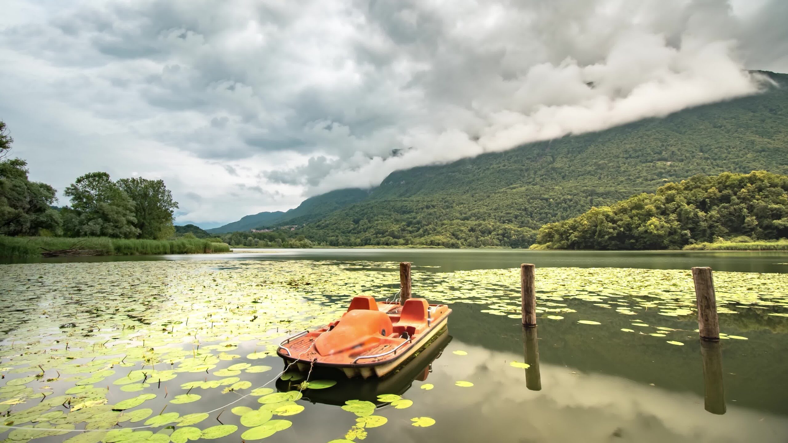Bellissimo paesaggio di un lago tra le montagne con barca che si muove sull’acqua