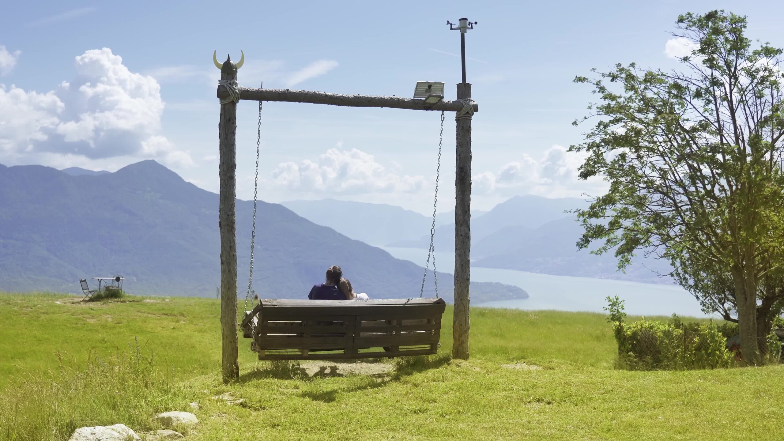 Copy of lovers swing on the swing in front of the beautiful landscape of Lake Como