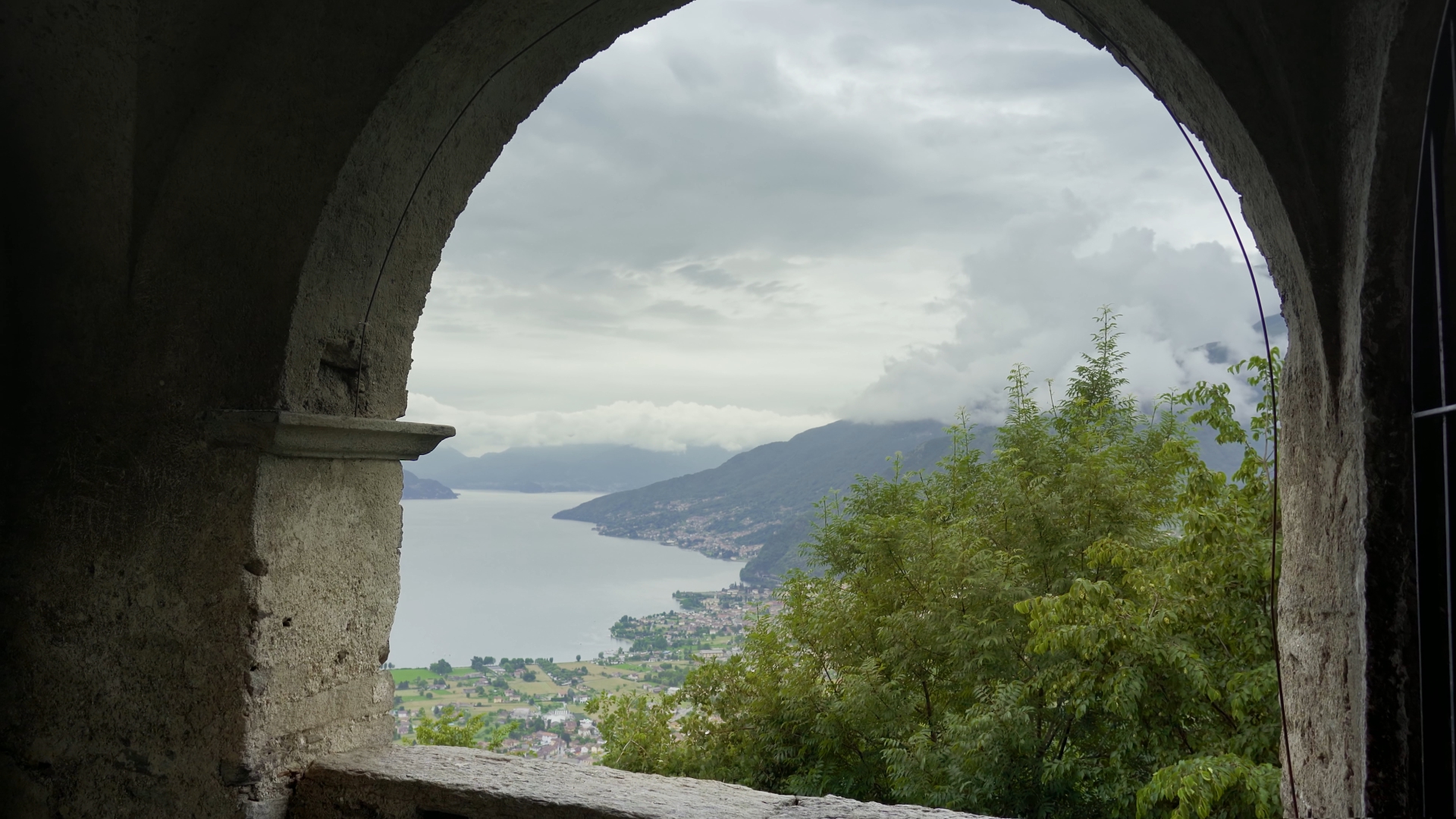 Lago di Como si apre dietro un arco dell’edificio antico