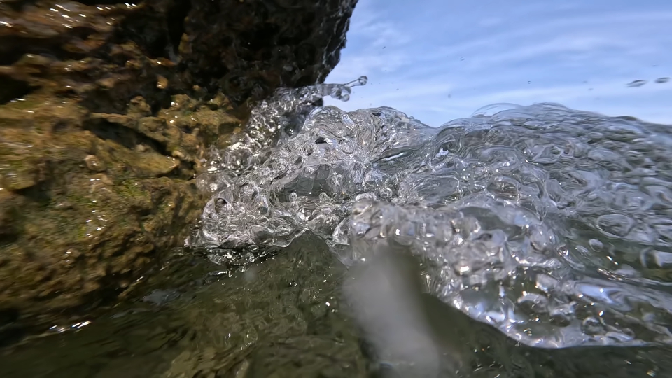 Onde del mare bagnano sassi al rallentatore