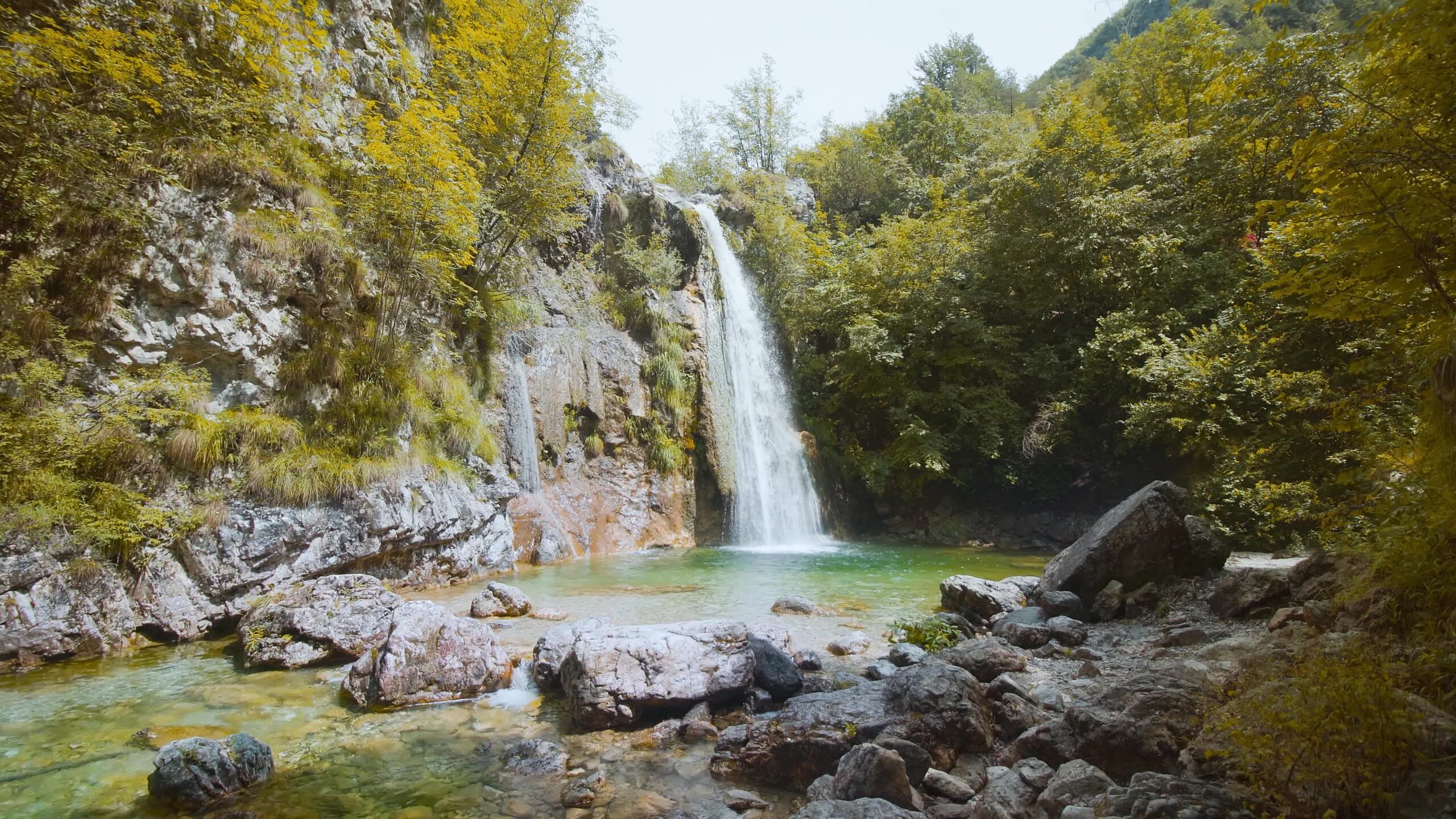 Piccola cascata tra alberi colorati