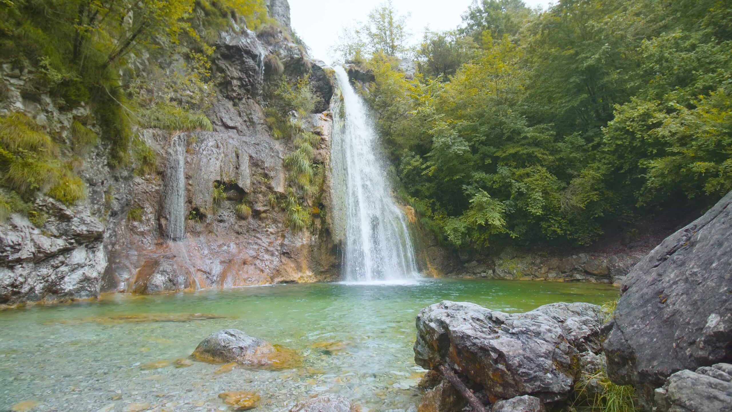 Cascata tra rocce e alberi verdi