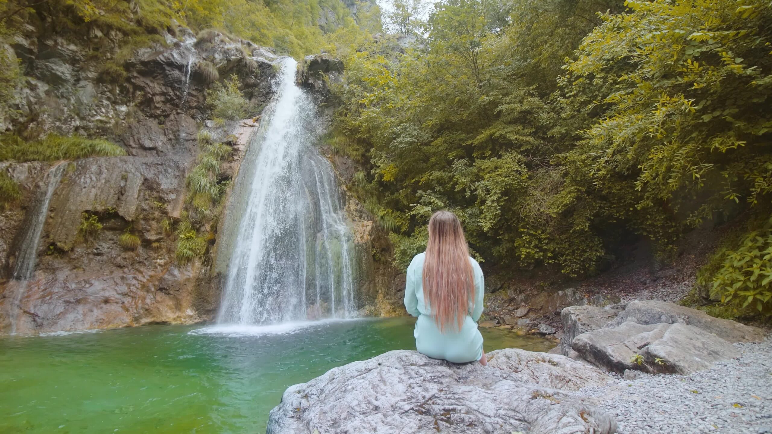 Donna seduta davanti la cascata