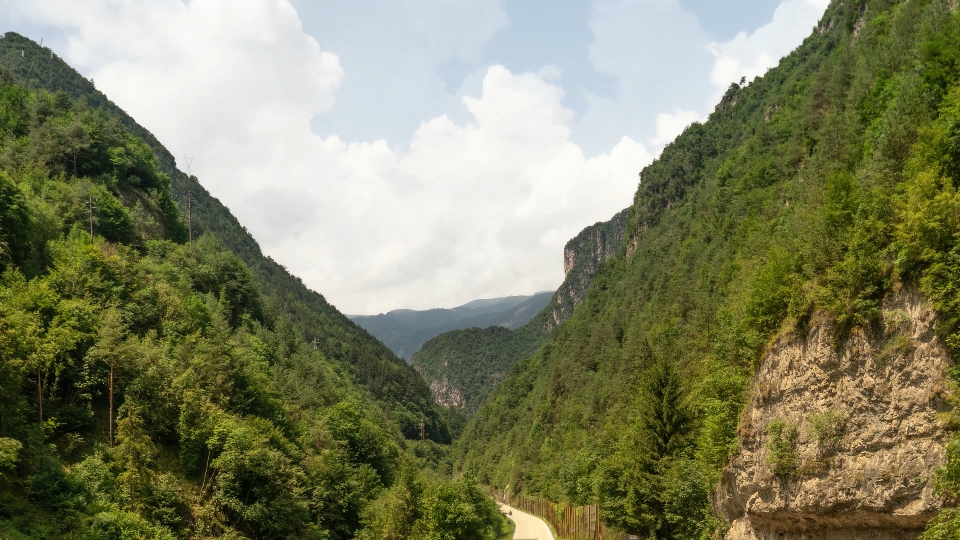 Timelapse on the green mountains in front of a road