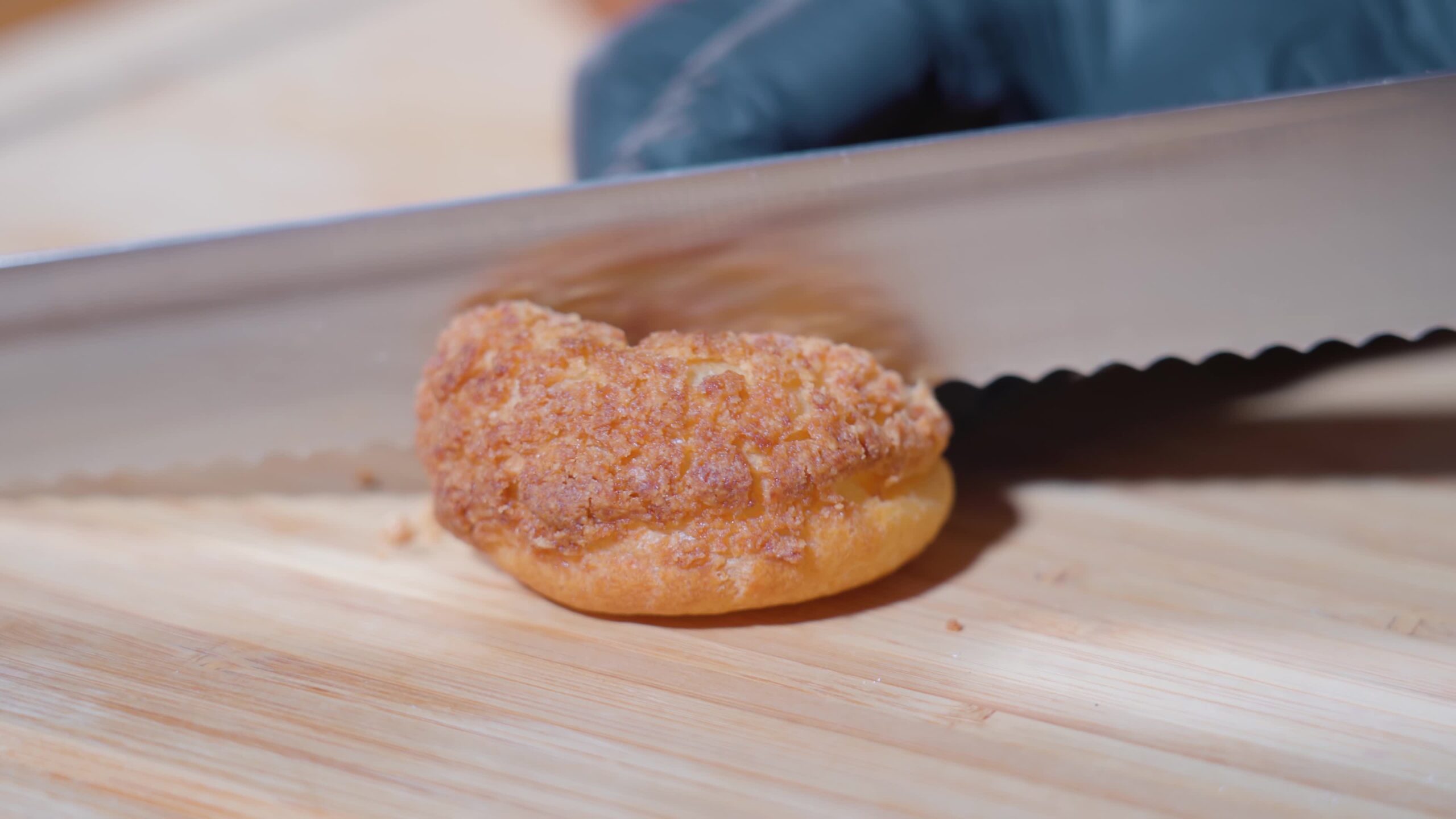 The choux pastry is cut in half with a knife