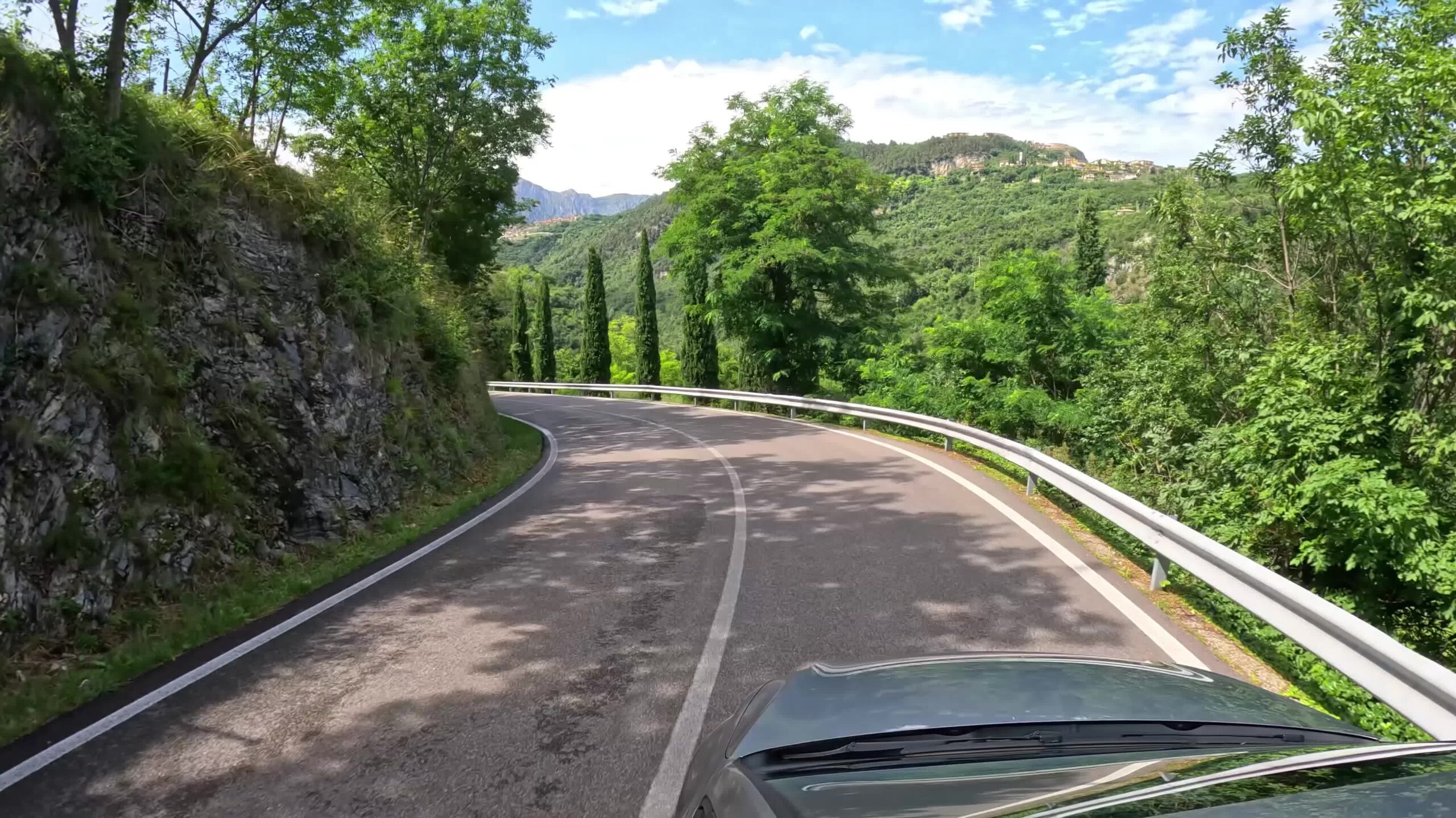 Automobile si sposta sulla strada delle montagne verdi