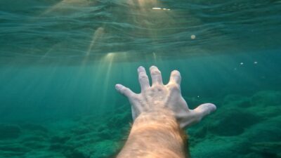 Man's hand drowning in the sea