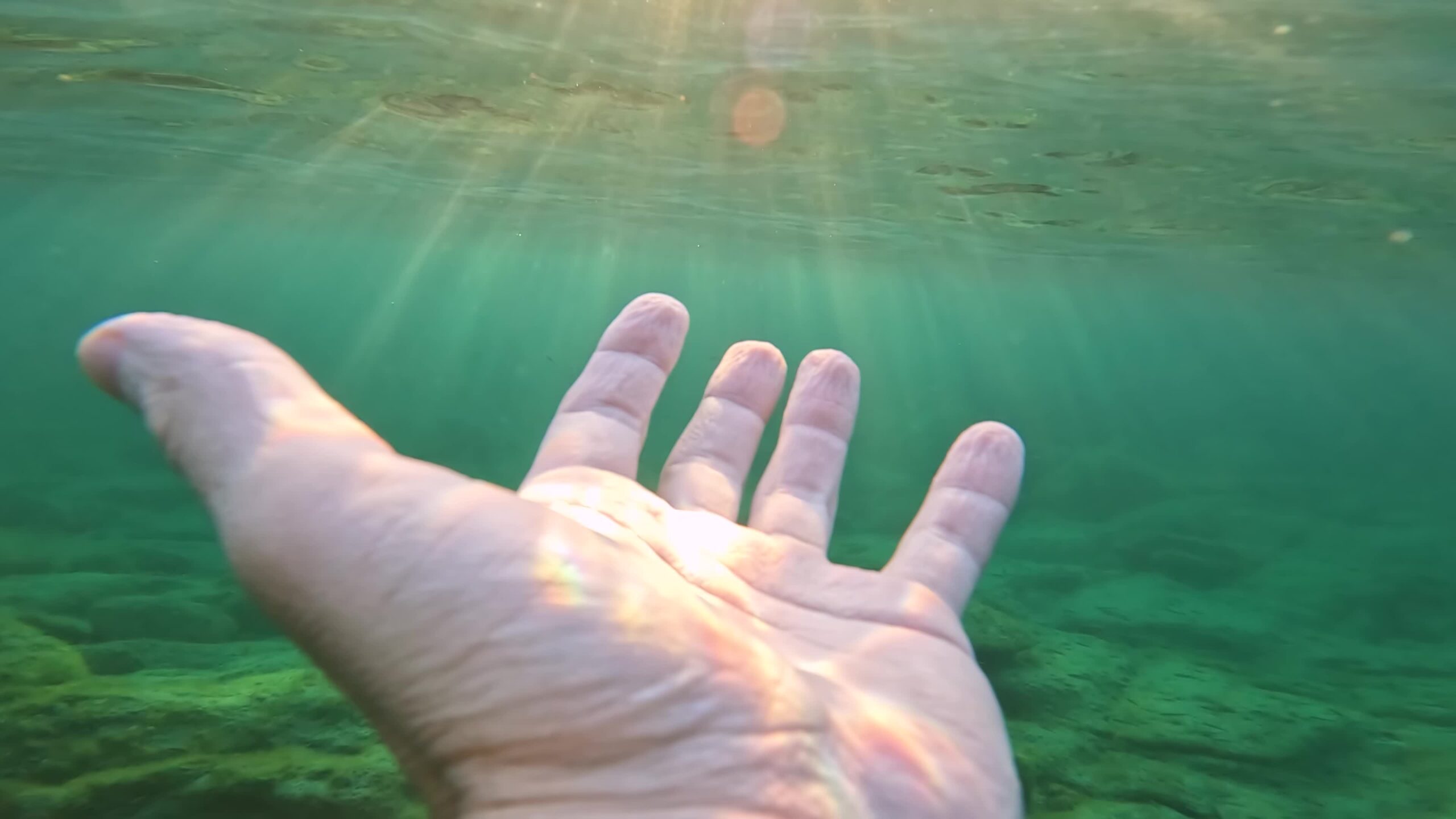 Raggi solari del mare illuminano la mano