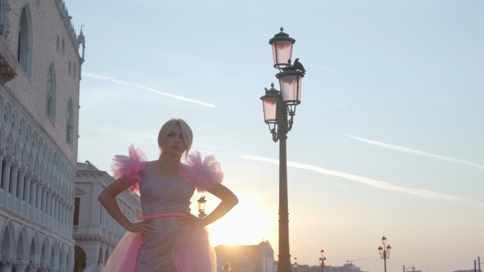 Modella in abito rosa posa al tramonto