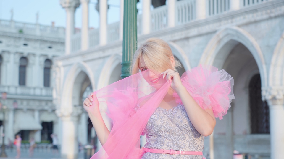 Close-up of blonde’s face in elegant pink dress