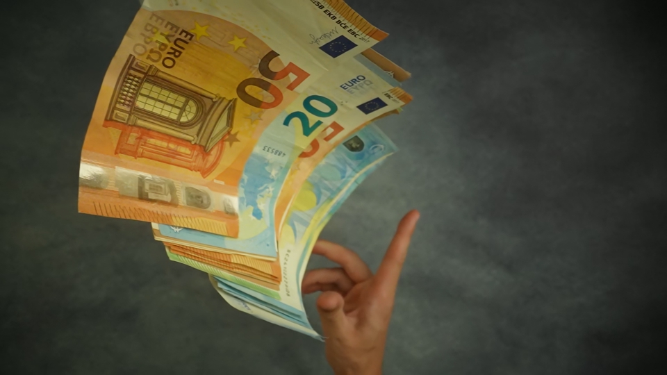 Mano lancia mucchio di banconote