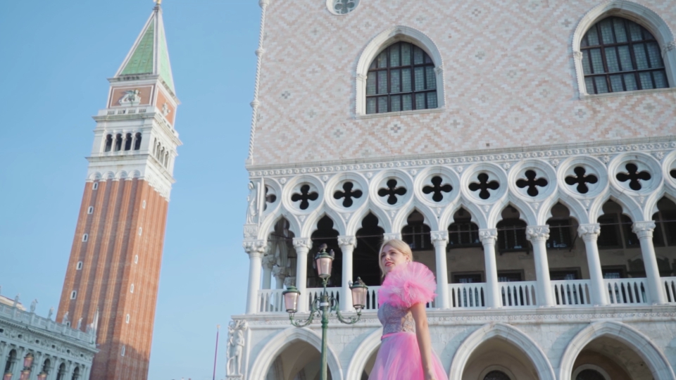 Turista elegante cammina a Venezia davanti palazzo Ducale
