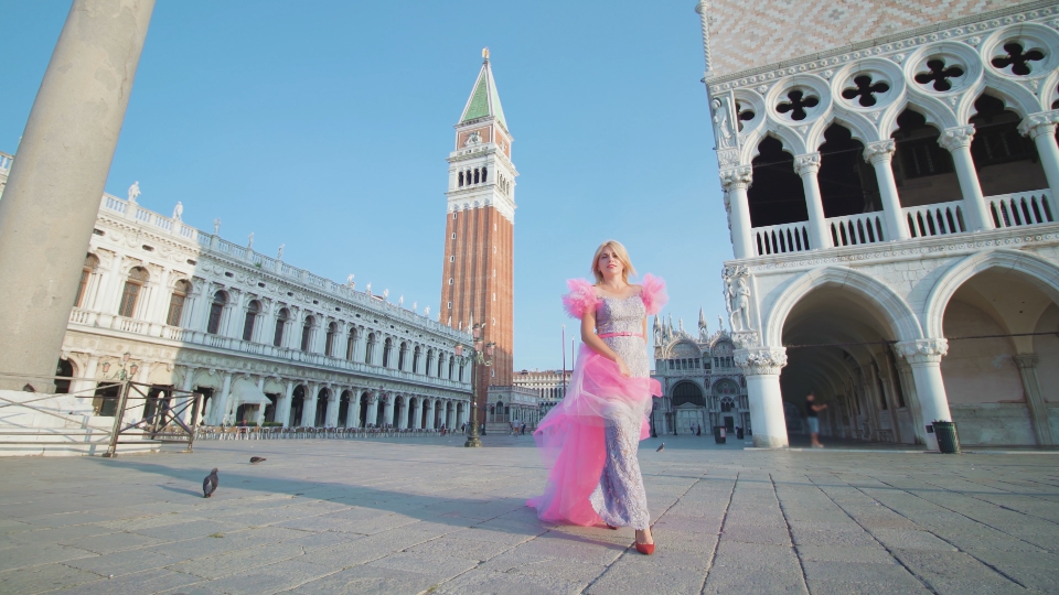 Modella elegante cammina a Venezia in piazza