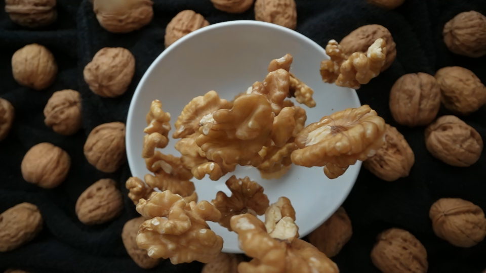Shelled Walnuts Landing on a Plate